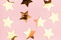 Modern festive background with golden shimmer stars on soft light pink background, pattern. Royalty Free Stock Photo