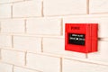 Modern fire call point on brick wall indoors