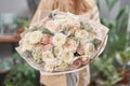 Modern floral shop. Finished work of the florist. Cute bouquet of mixed flowers in womans hands. Delivery fresh cut