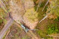 Modern forest harvester in an autumn forest from above