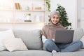 Modern Freelance Concept. Young arabic woman working on laptop computer at home Royalty Free Stock Photo