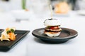 Modern French appetizer: Mini hamburger including white bun, pork, sliced cucumber, tomato and raddish topping with black sesame Royalty Free Stock Photo