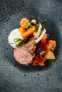 Modern French cuisine: Close up roasted Lamb neck & rack served with carrot, yellow curry served in black stone plate