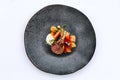 Modern French cuisine: Roasted Lamb neck & rack served with carrot, yellow curry served in black stone plate