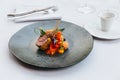 Modern French cuisine: Roasted Lamb neck & rack served with carrot, yellow curry served in black stone plate Royalty Free Stock Photo