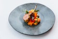 Modern French cuisine: Roasted Lamb neck & rack served with carrot, yellow curry served in black stone plate Royalty Free Stock Photo