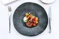 Modern French cuisine: Roasted Lamb neck & rack served with carrot, yellow curry served in black stone plate with fork and knife Royalty Free Stock Photo