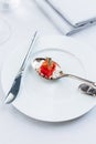 Modern French food: Diced watermelon with white crush cheese served in silver spoon on white plate with cutlery as appetizer Royalty Free Stock Photo