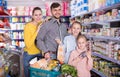 Modern friendly family of four with full basket