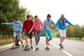 Modern friendly guys in casual clothes skateboarding and showing exciting tricks