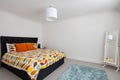 Modern furnished bedroom in new home with multicolor duvet