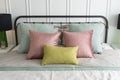 Bedroom with pastel pink and green accents pillows. Royalty Free Stock Photo