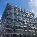 Modern futuristic office building with reflection of clouds and blue sky on the glass windows Royalty Free Stock Photo