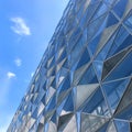 Modern futuristic office building with reflection of clouds and blue sky on the glass windows Royalty Free Stock Photo