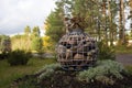 Modern Gabion with natural granite stones in a wire mesh stands on a flower bed in the park. A flower grows on top of Royalty Free Stock Photo