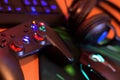 Modern gamepad and gaming mouse lies with keyboard and headphones on table in dark playroom scene. Video gaming addiction among Royalty Free Stock Photo