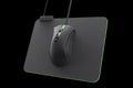 Modern gaming mouse on professional pad on black background with clipping path