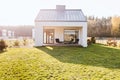 Garden furniture on the terrace of stylish suburban house with big green yard