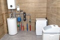 A modern gas boiler room lined with ceramic tiles imitating wood, visible full boiler room equipment with a washing machine and wa