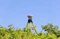 A modern geodesic receiver operates autonomously in the field among wild raspberry thickets Royalty Free Stock Photo