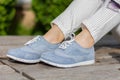 Stylish Steps: Fashionable Woman\'s Legs in Blue Sneakers at the Park