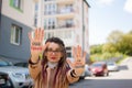 Modern girl with long dreadlocks and eyeglasses in nude color trench is showing hands with written slogan `Our future in Royalty Free Stock Photo