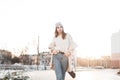 Modern glamorous young woman model in stylish warm seasonal outerwear walks on the street. Urban girl in fashionable youth clothes Royalty Free Stock Photo