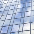 Modern glass building with reflections of blue sky and clouds Royalty Free Stock Photo