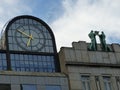 Modern glass clock with two stylized bronze statues to Prague, Czech Republic.