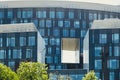 Modern glass commercial exterior of office building architecture. Window covered abstract building with green trees in Royalty Free Stock Photo