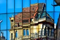 Modern glass curtain wall building facade with strong reflections. classic old building mirrored in the glass Royalty Free Stock Photo