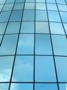 modern glass facade of a skyscraper in perspective with reflected clouds
