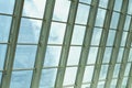 Modern glass office building with clouds and sky.