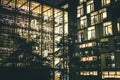Modern glass office building with yellow lights at night. Modern architecture. Royalty Free Stock Photo