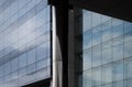 Modern glass office buildings behind a steel column with blue sky clouds and sunlight reflected in glass windows Royalty Free Stock Photo