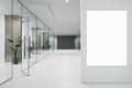 Modern glass office corridor with blank mock up poster on wall, furniture and concrete flooring. Royalty Free Stock Photo