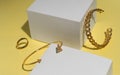 Modern golden arrow shape and chain shape bracelets and ring on yellow background Royalty Free Stock Photo