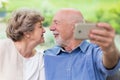 Grandpa and grandma looking for each other and taking selfie for social media account