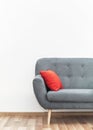 Modern gray couch with red pillows on wooden tiled floor - office furniture, white wall - space for text - above