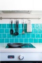 Kitchen features dark gray flat front cabinets paired with white quartz countertops and a glossy blue care tile. Royalty Free Stock Photo