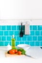 Kitchen features dark gray flat front cabinets paired with white quartz countertops and a glossy blue care tile. Royalty Free Stock Photo