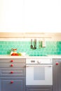 Kitchen features dark gray flat front cabinets paired with white quartz countertops and a glossy blue care tile. Royalty Free Stock Photo