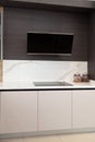 Modern gray white lacquer wood kitchen cabinet and black electric stove and hood on white granite countertop Royalty Free Stock Photo