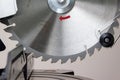 Modern green circular saw lies on a wooden table. Circular saw blade for wood with hard alloy insertions