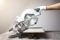 Modern green circular saw lies on a wooden table. Circular saw blade for wood with hard alloy insertions