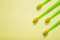 Modern green kids toothbrushes on a yellow background. Copy space for your text Royalty Free Stock Photo