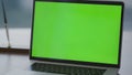 Modern green screen laptop placed on office desk close up. Chroma key computer. Royalty Free Stock Photo