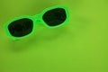 Modern green sunglasses isolate on a green background.Traveler and summer accessories Royalty Free Stock Photo