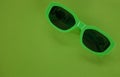 Modern green sunglasses isolate on a green background.Traveler and summer accessories