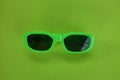 Modern green sunglasses isolate on a green background.Traveler and summer accessories